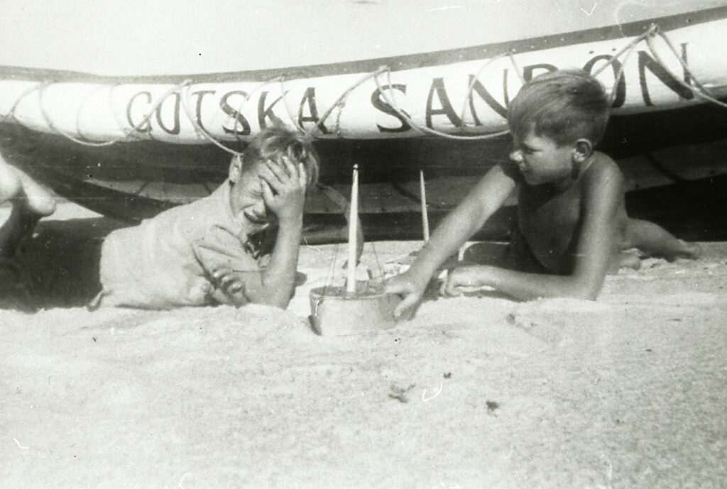 Bröderna Göran och Hans Hörlin leker vid Sandöns livräddningsbåt 1947. Foto: Gotska Sandöns hembygdsförenings arkiv.